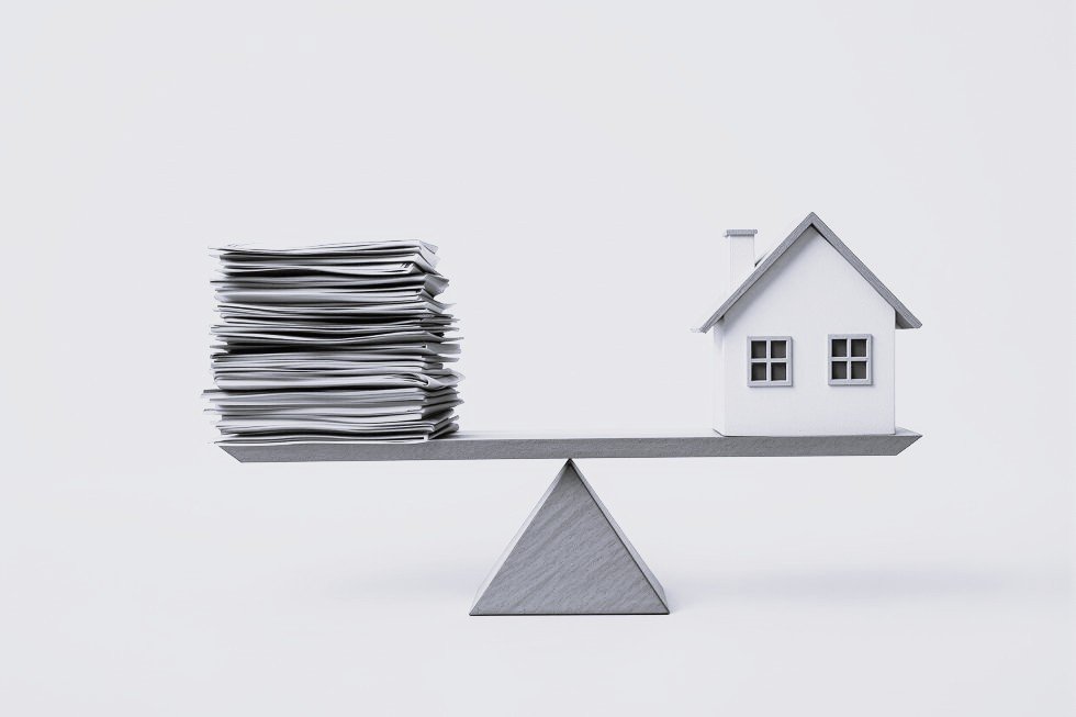 Balance entre pile de documents et maison symbolisant l'équilibre financier immobilier — DB France Invest, financement immobilier